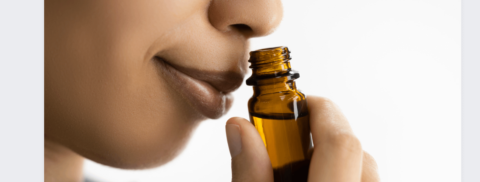 Lady sniffing an essential oils bottle to control anxiety